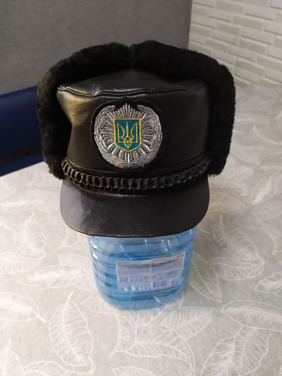 Embroidered Tryzub patch with silver-tone wreath on the winter uniform hat – detail 5