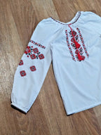 Girls peasant blouse laid flat with measuring tape