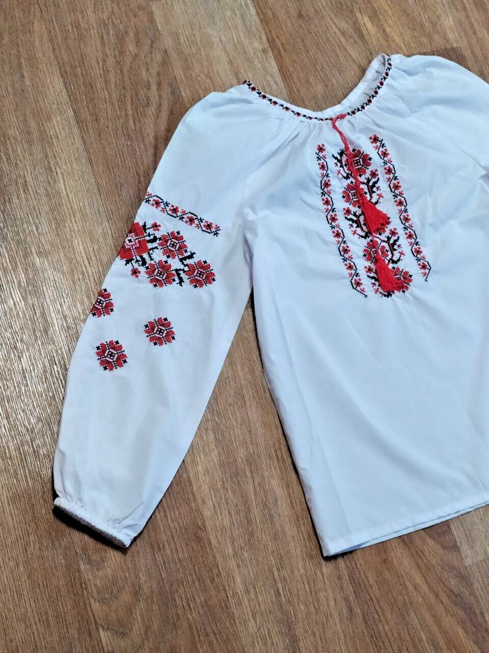 Girls peasant blouse laid flat with measuring tape