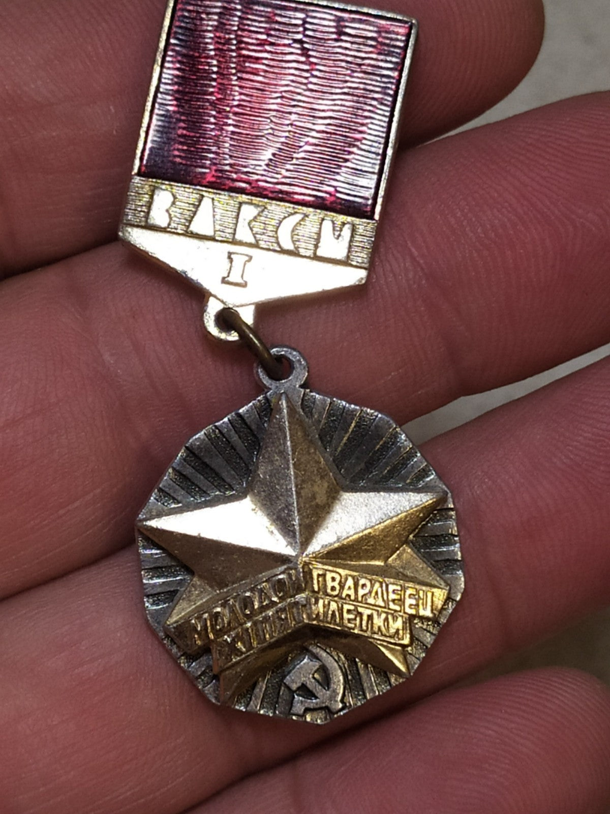 Vintage VLKSM Komsomol award pin on plain background