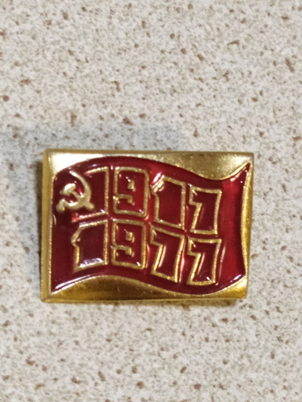Vintage Soviet pin marked 1917-1977 with a flag