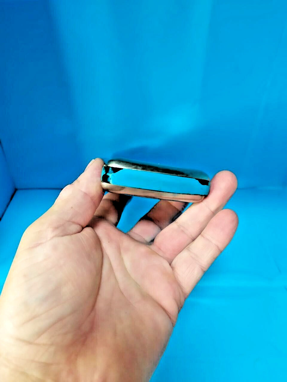 Pocket-size East German Vermona harmonica shown against a hand for scale – detail 10