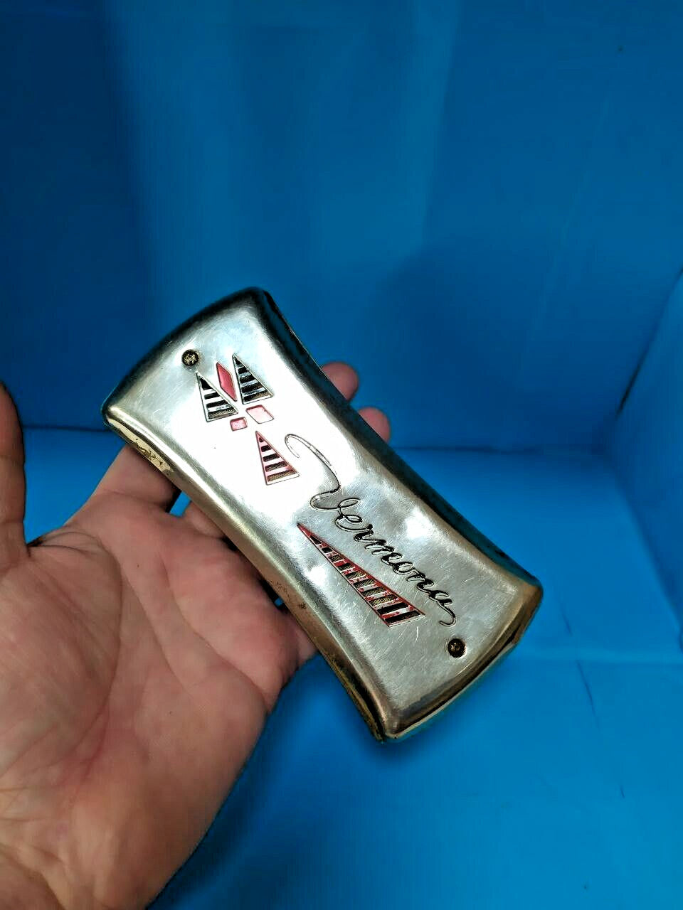 Pocket-size East German Vermona harmonica shown against a hand for scale – detail 13