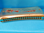 GDR Vermona harmonica with red and black logo and geometric cutouts on chrome covers
