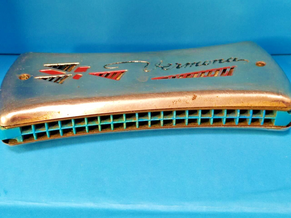 GDR Vermona harmonica with red and black logo and geometric cutouts on chrome covers