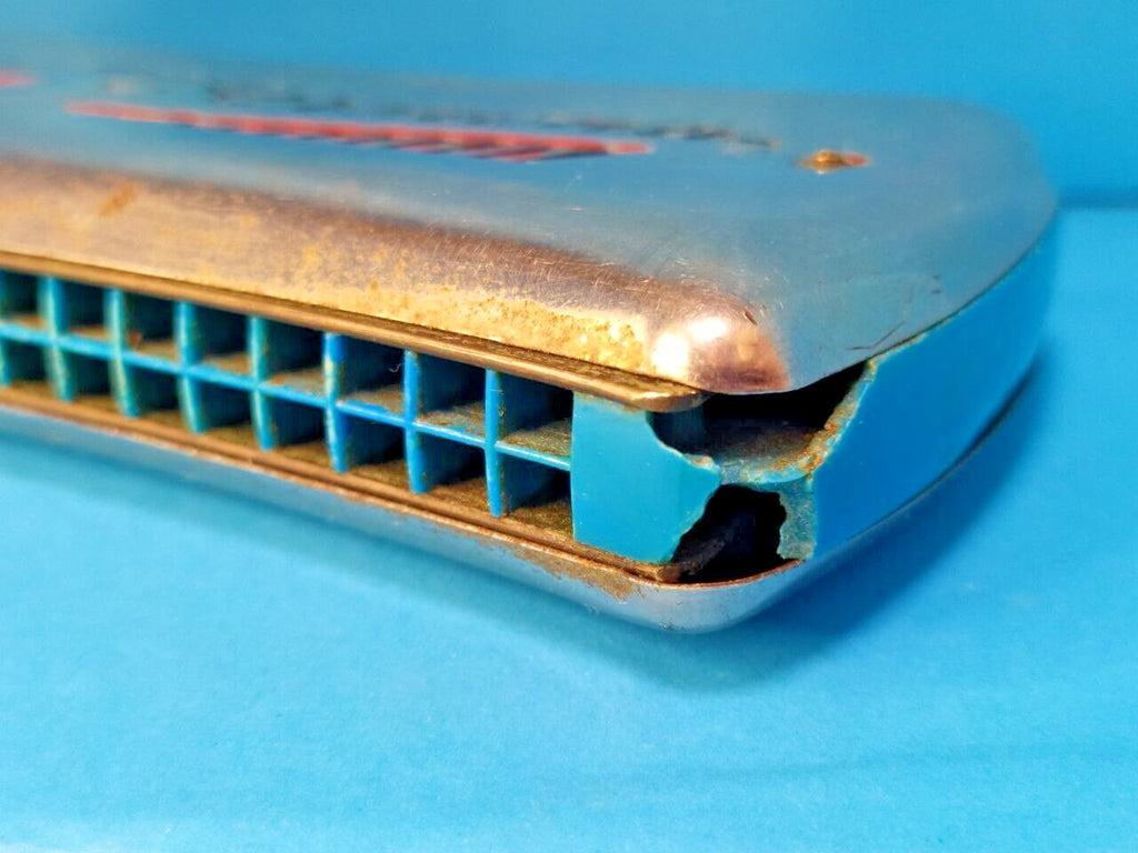 Pocket-size East German Vermona harmonica shown against a hand for scale