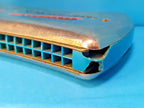 Pocket-size East German Vermona harmonica shown against a hand for scale