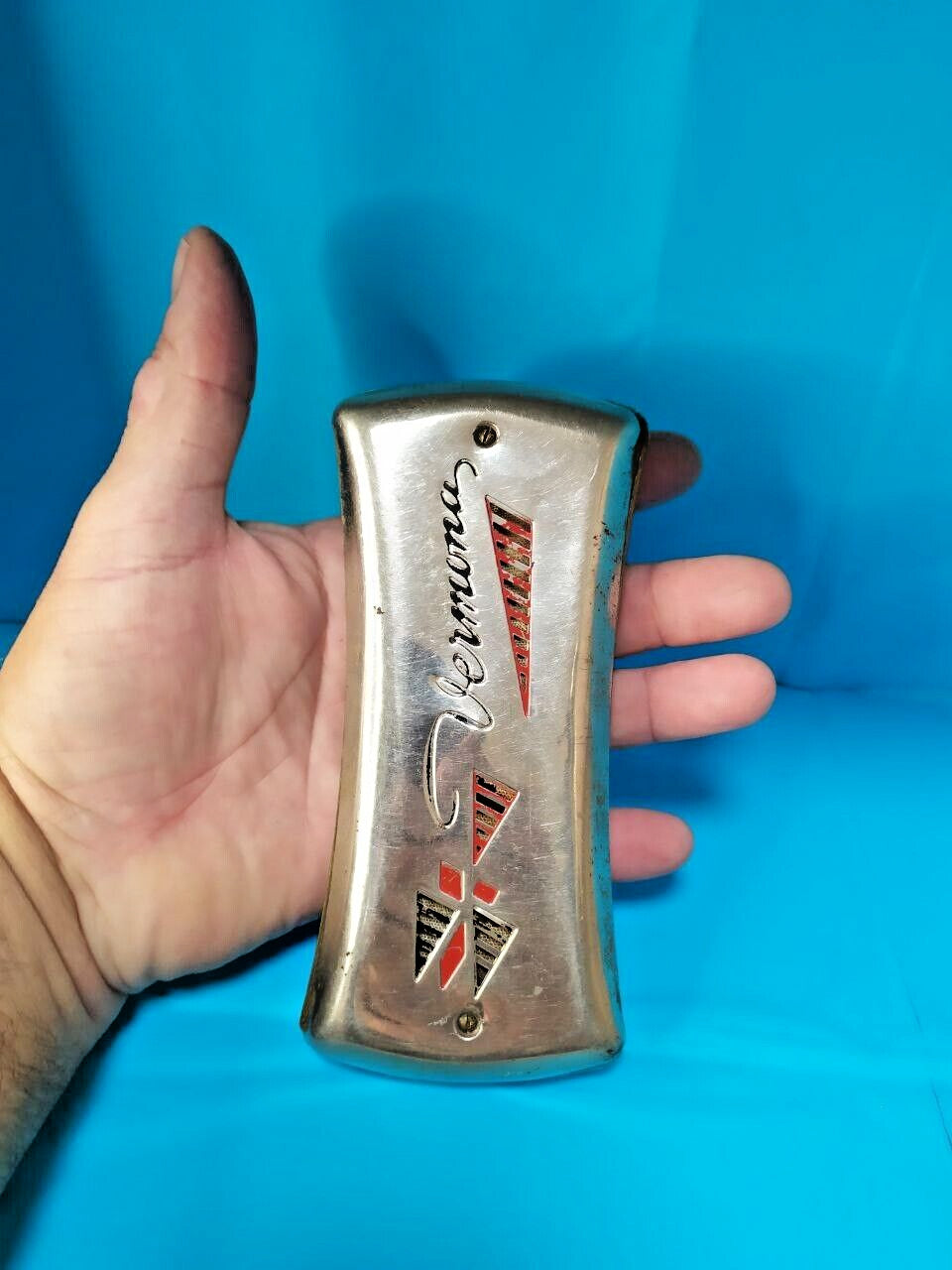 Pocket-size East German Vermona harmonica shown against a hand for scale – detail 7