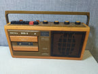 Orange and brown Soviet tape recorder with carrying handle and Cyrillic labels