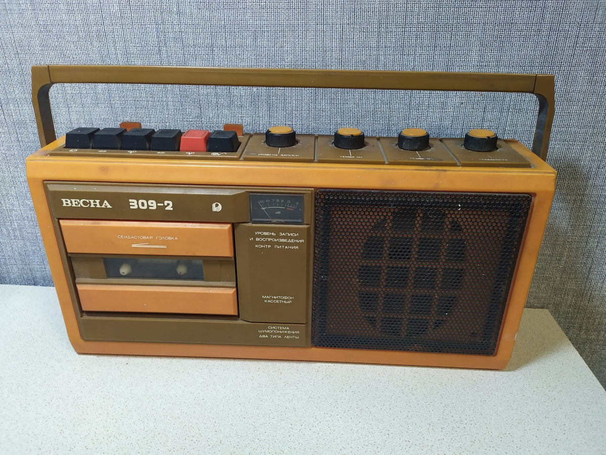 Orange and brown Soviet tape recorder with carrying handle and Cyrillic labels