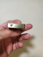 Back of the vintage gas lighter with smooth brass and vent holes