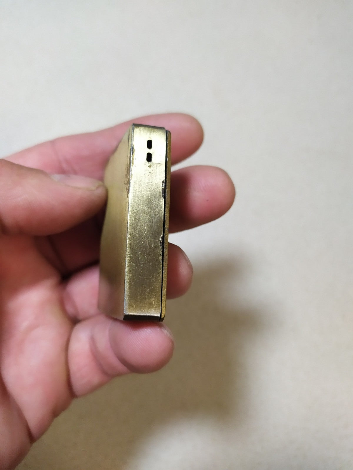 Lighter bottom showing refill valve and flame adjustment screw