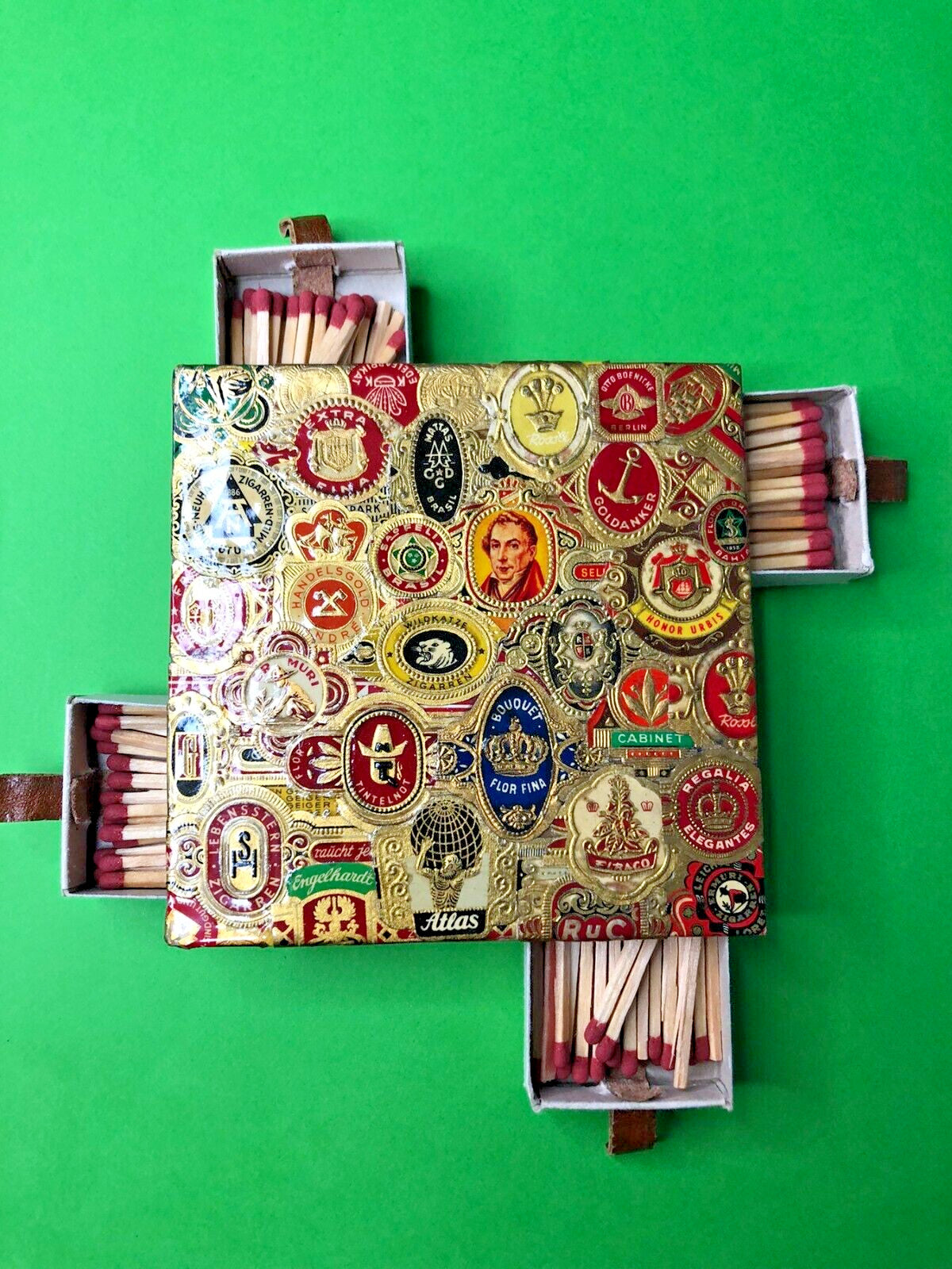 Vintage matchbox holder decorated with decoupage of authentic cigar bands