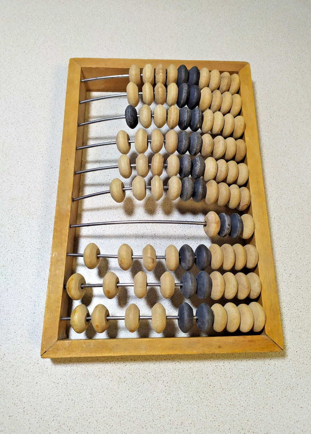 Soviet wooden abacus, close-up of natural and dark beads on metal rods