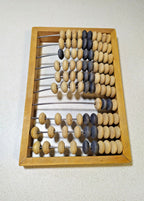 Soviet wooden abacus, close-up of natural and dark beads on metal rods