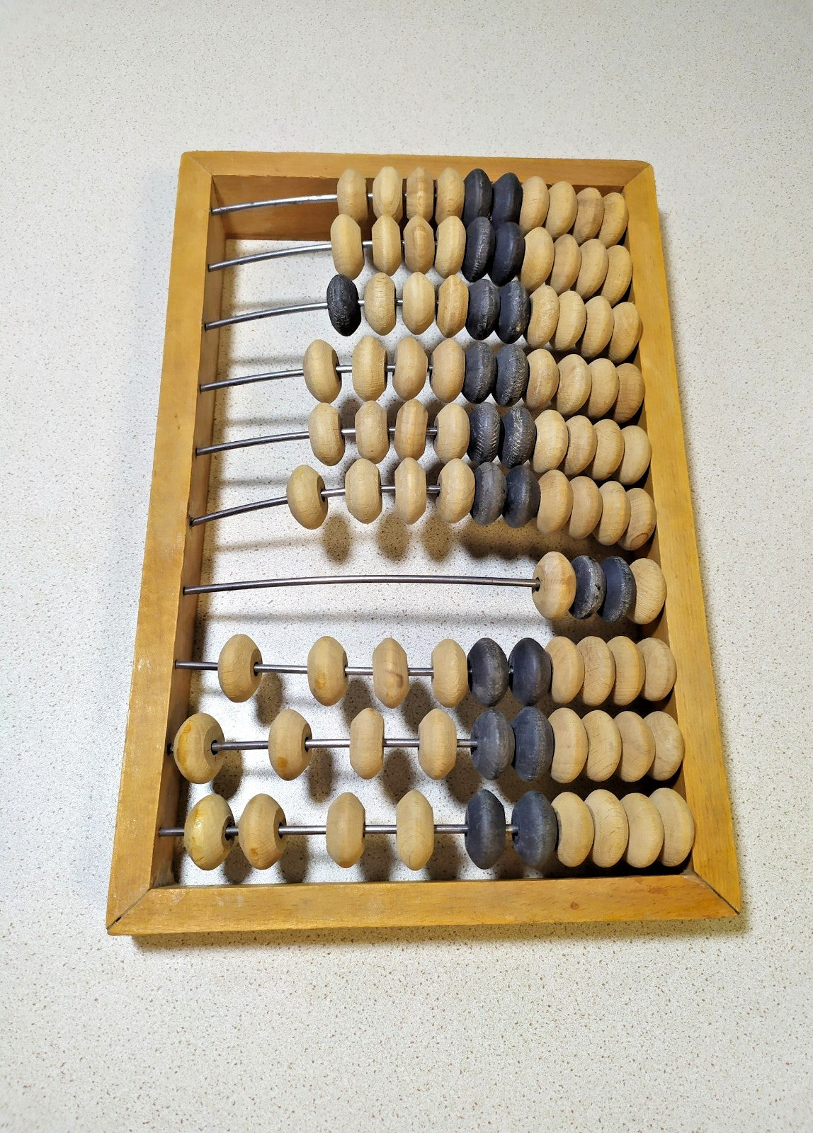 Soviet wooden abacus, close-up of natural and dark beads on metal rods