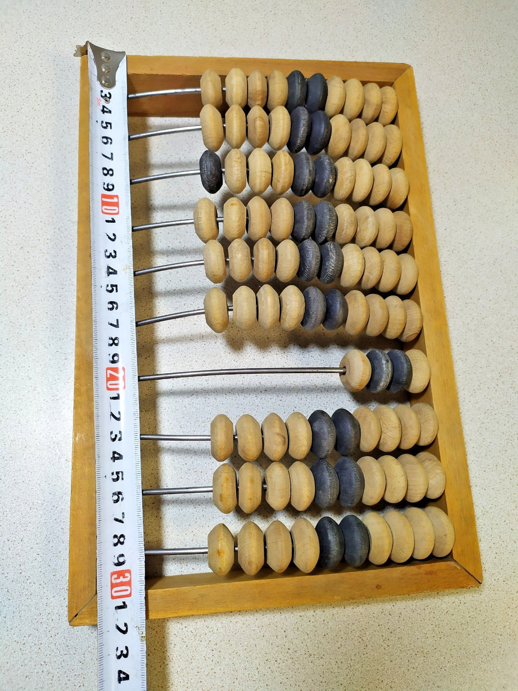 Soviet wooden abacus, close-up of natural and dark beads on metal rods – detail 5