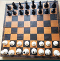 Vintage Soviet chess set with plastic pieces set up on a wooden board