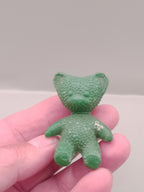 Vintage Soviet toy: small green rubber teddy bear figure with bumpy texture