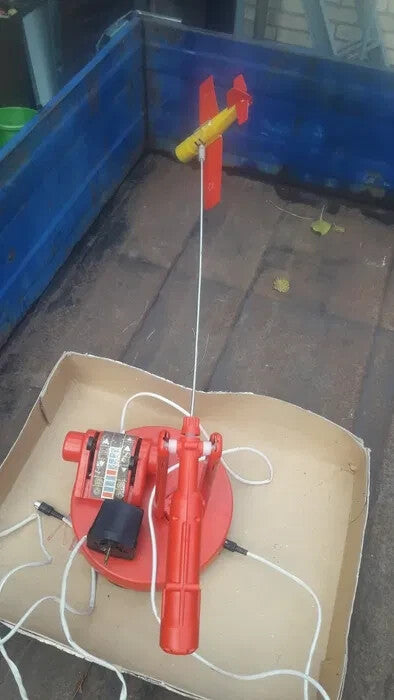 Soviet electric toy plane in red and yellow plastic on its base