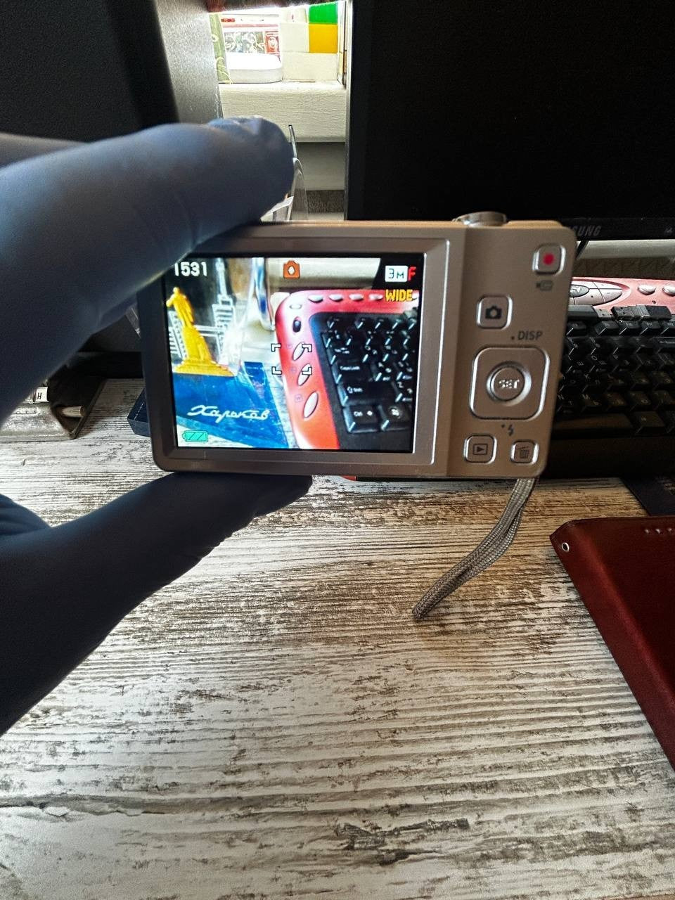 Silver Casio EX-Z88 compact digital camera with attached wrist strap