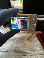 Silver Casio EX-Z88 compact digital camera with attached wrist strap
